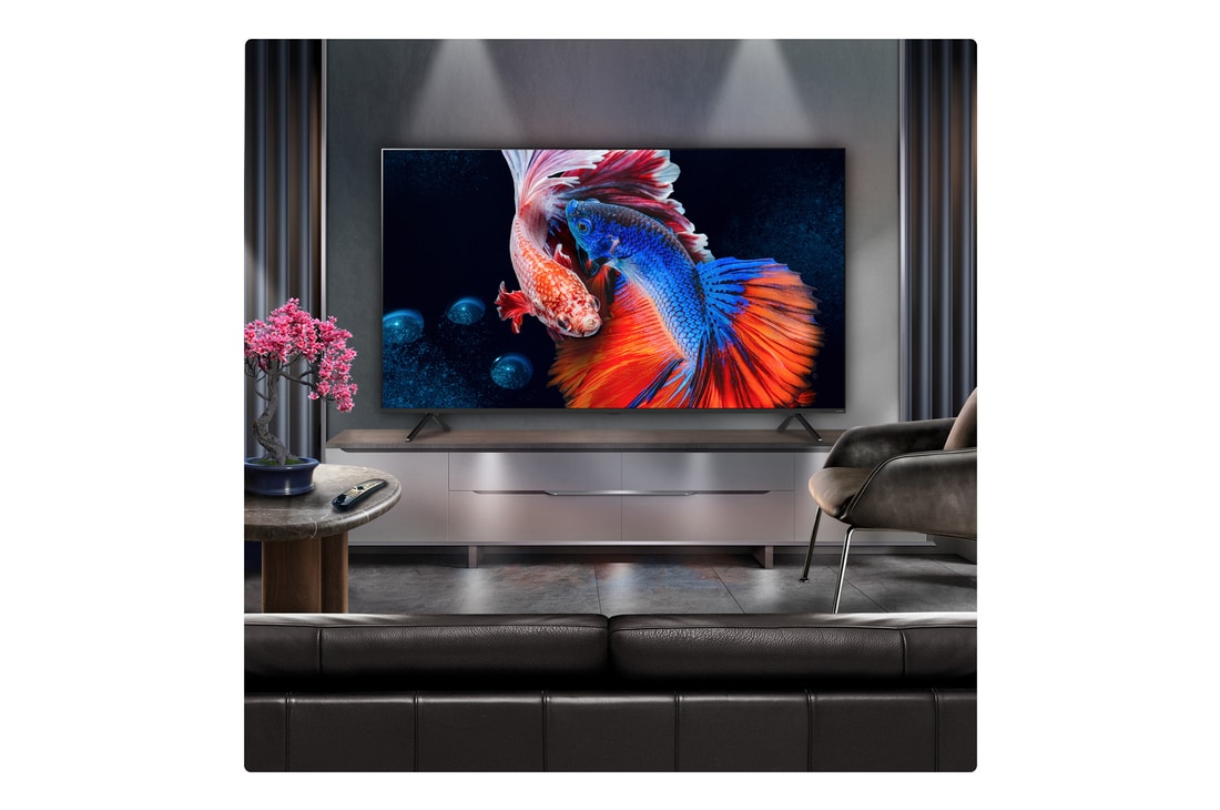 A family sits on a couch facing a LG QNED TV sitting above a TV stand with a little girl pointing to a screen depicting two dolphins. The title talks about how you can enjoy high resolution on a massive screen.