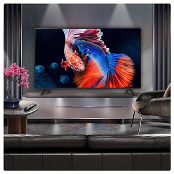 A family sits on a couch facing a LG QNED TV sitting above a TV stand with a little girl pointing to a screen depicting two dolphins. The title talks about how you can enjoy high resolution on a massive screen.