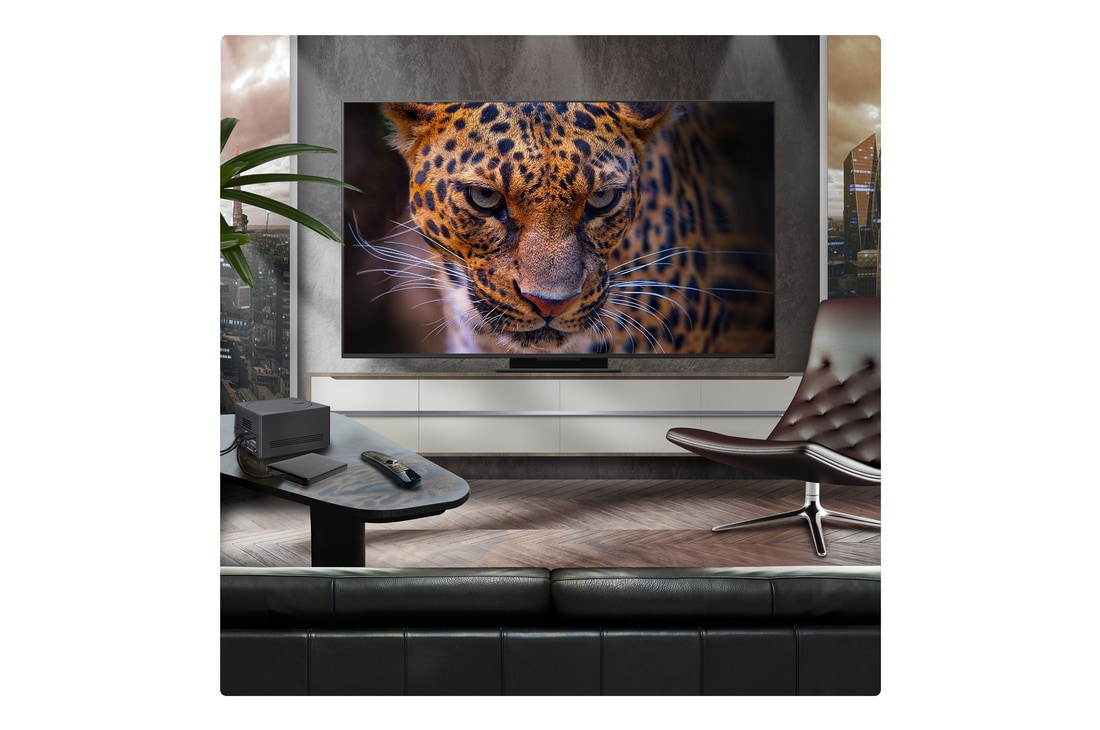 A family sits on a couch facing a LG QNED TV mounted on a wall above a LG Soundbar with a little girl pointing to a screen depicting two dolphins. The title talks about how every action is more thrilling on a massive screen.