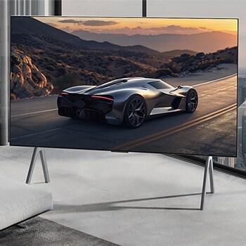 Wide view of a living room inside a premium home, a man is watching a movie on his wall-mounted LG OLED TV. The TV's design blends elegantly with the wall and the interior design.