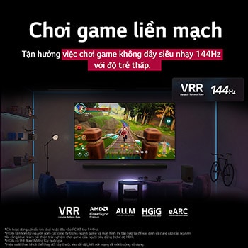 Phòng khách được chiếu sáng mờ với màn hình trò chơi được hiển thị trên QNED9M. Hộp kết nối không dây nằm bên trong bàn cà phê. Văn bản nói về chơi game không dây siêu nhạy 144Hz với độ trễ thấp.