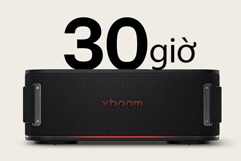 xboom Bounce được đặt trên nền đất phủ đầy lá ướt, nằm giữa rễ cây và một hòn đá. Ở góc trên bên trái có logo tiêu chuẩn quân đội