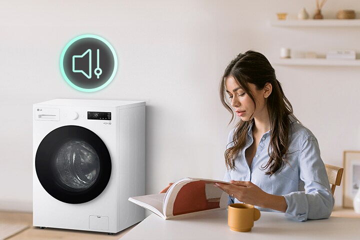 Người phụ nữ đang ngồi ở bàn đọc sách và cho thấy các biểu tượng và máy giặt gây ít tiếng ồn hơn bên cạnh	