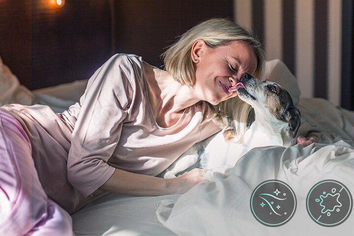 Một người phụ nữ và chú chó đang nằm trên giường	