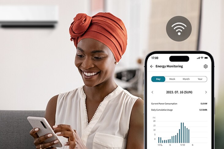 Người phụ nữ sử dụng ứng dụng LG ThinQ với kW Manager để theo dõi mức sử dụng năng lượng và xem biểu đồ tiêu thụ trên điện thoại.