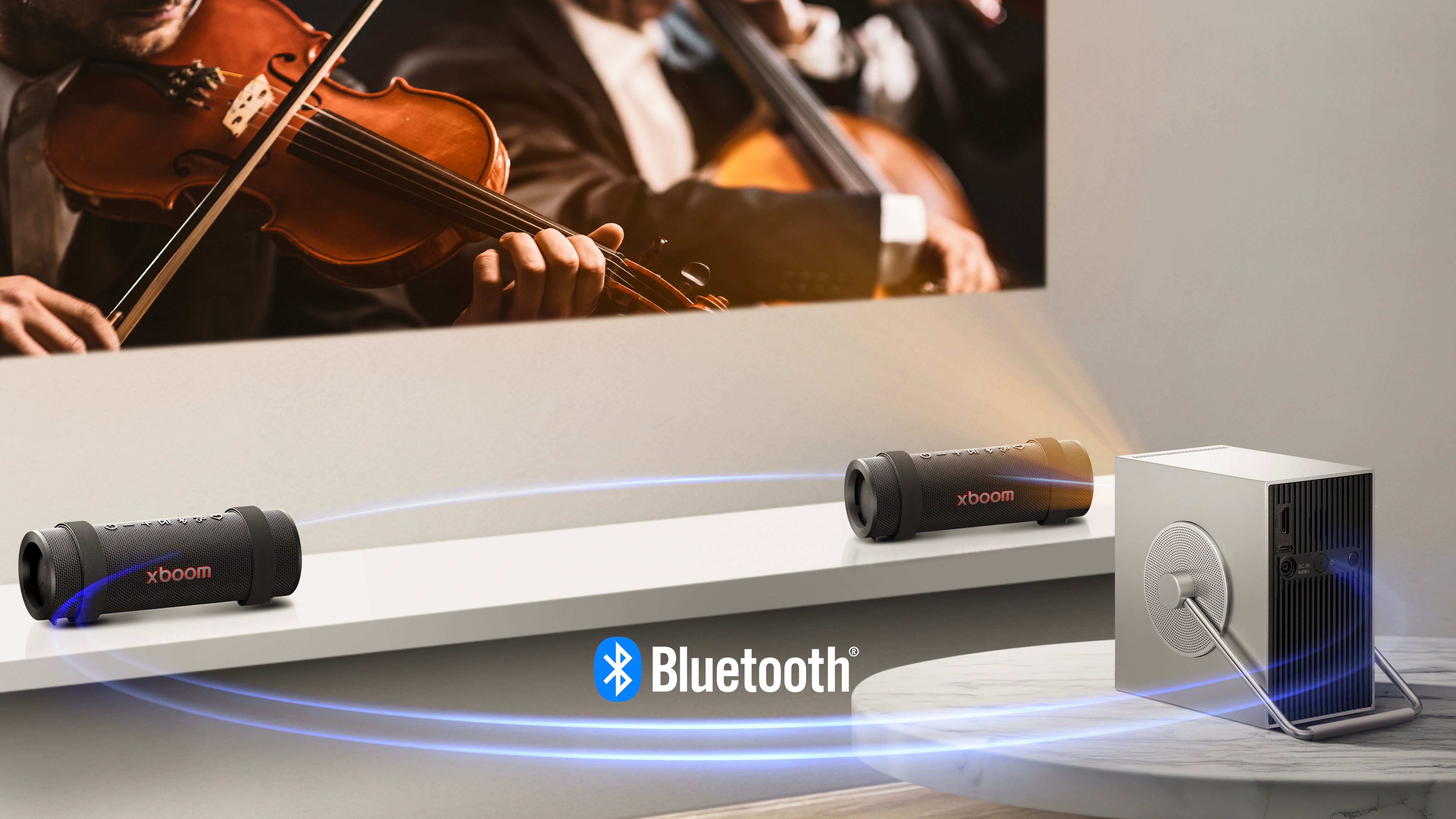 LG CineBeam Q projector is projecting concert scene onto the wall and two units of xboom Grab are placed on both side below the screen. Virtual blue light streak is connecting all 3 of them to show they're connected via bluetooth. 	