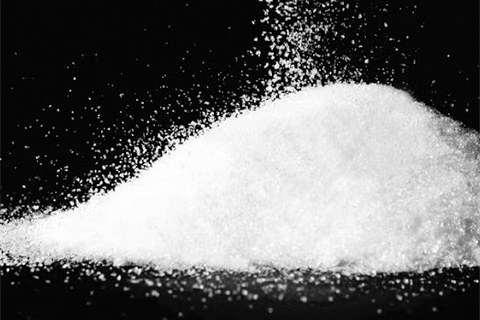 Pile of white detergent powder on black background