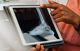Doctor and patient reviewing a chest X-ray on a digital screen in a medical consultation room
