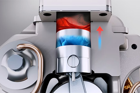 Close-up of a mechanical piston moving upward, showing blue and red airflow representing cooling and heating inside the chamber.