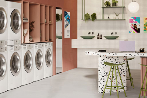 Modern self-service laundry lounge interior with LG washers and dryers and bar-style seating area