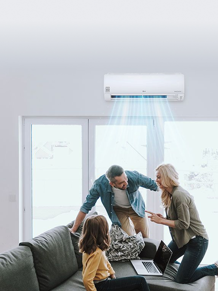 A wall-mounted air conditioner supplying blue-colored air stream in a living room while three family members smiling at each other on a sofa