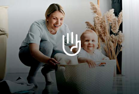 Smiling mother with baby holding laundry basket	
