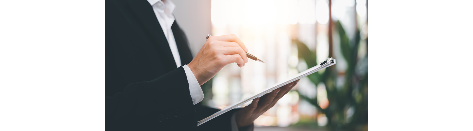 An image showing someone holding a pen and preparing to write something