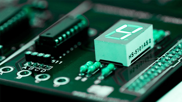 A complex circuit features a white rectangular component plugged in, boldly displaying the number four.