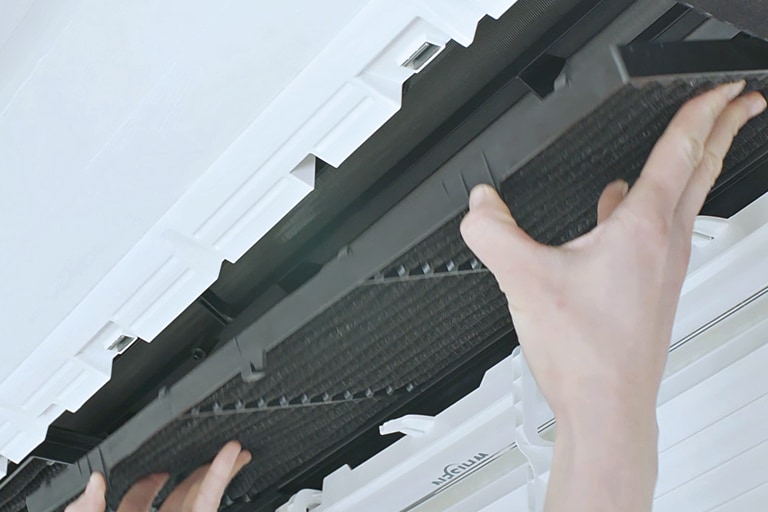 An individual is fitting a long, black, rectangular-shaped filter into the white body of the LG One Way Cassette.