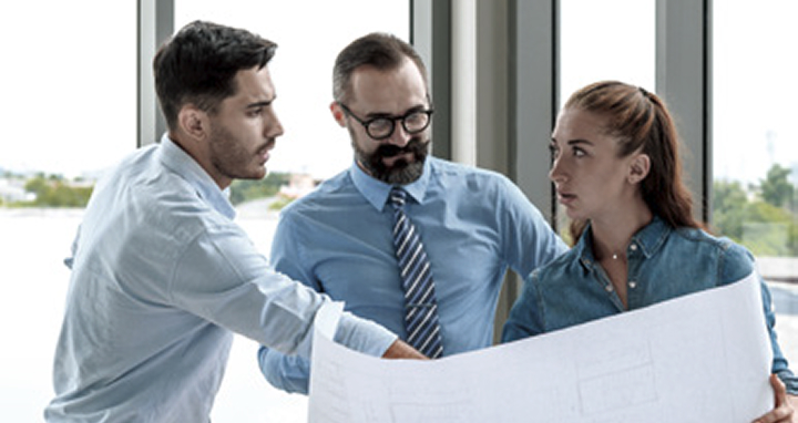 Engineering consultants discussing master plan and roadmap with blueprint for factory project.