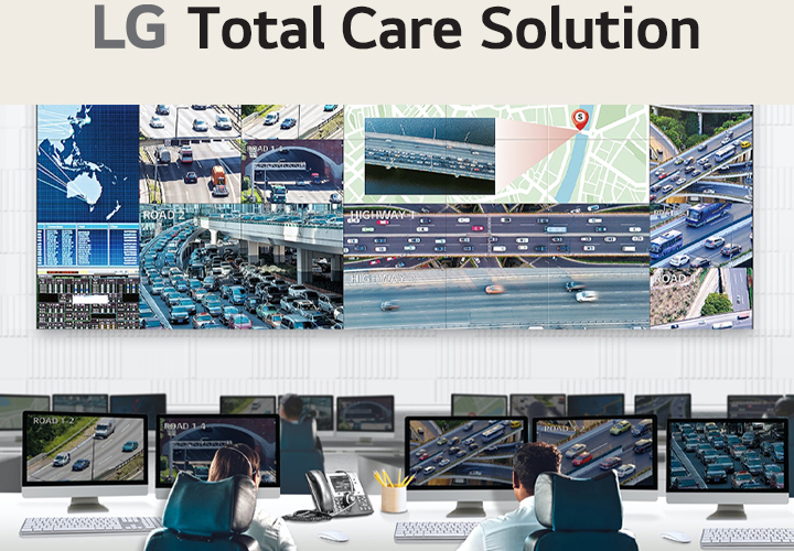 A traffic control room with multiple monitors displaying real-time footage of highways, traffic maps, and analytics. Two operators monitor the screens, showcasing advanced traffic management and surveillance systems.