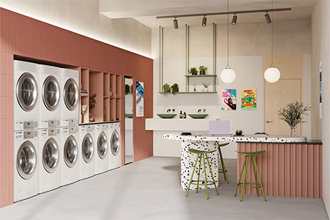 Modern self-service laundry lounge interior with LG washers and dryers and bar-style seating area