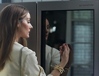 Olivia Palermo gently knocks on the LG SIGNATURE InstaView® Refrigerator glass panel twice.