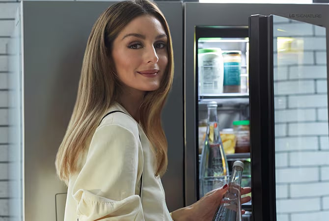 Olivia Palermo opens up the LG SIGNATURE InstaView® Refrigerator glass panel, revealing her go-to snacks.