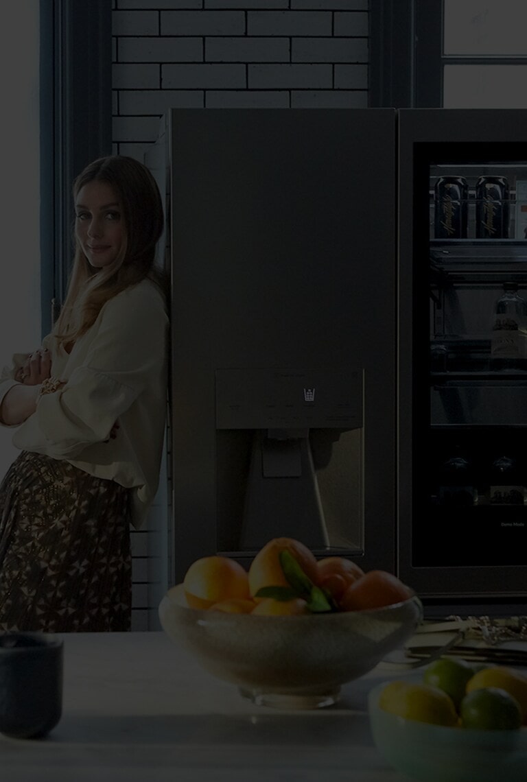 Olivia Palermo leans against the LG SIGNATURE Refrigerator.