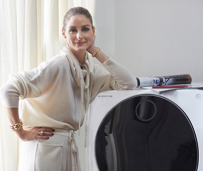 Olivia Palermo rests her arms on the LG SIGNATURE TWINWash® Washer Dryer Combo.