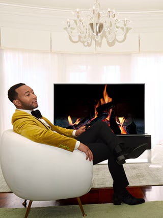 John Legend relaxing in front of a rollable TV