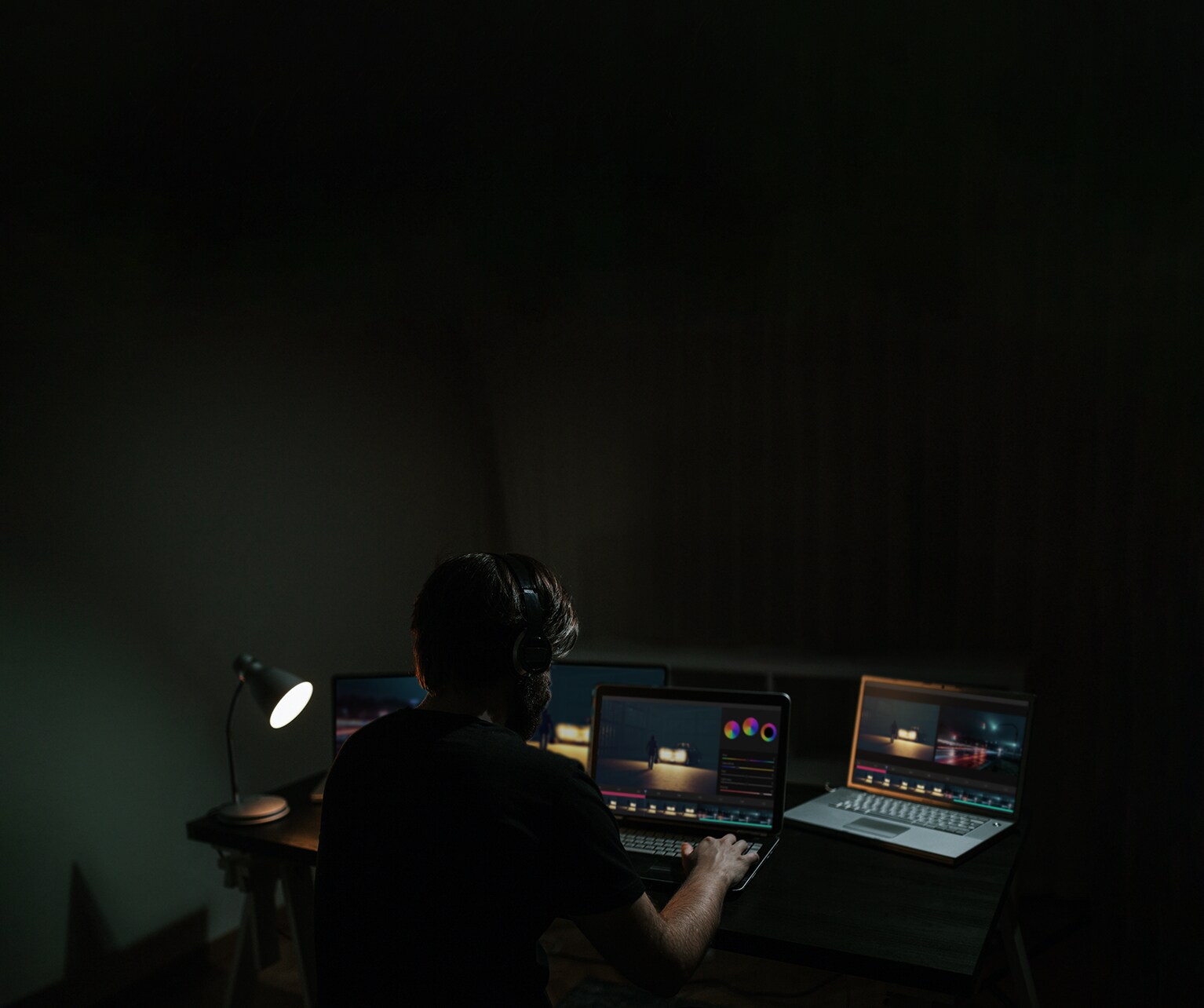 Un hombre edita una película mientras mira el software en el monitor de un ordenador