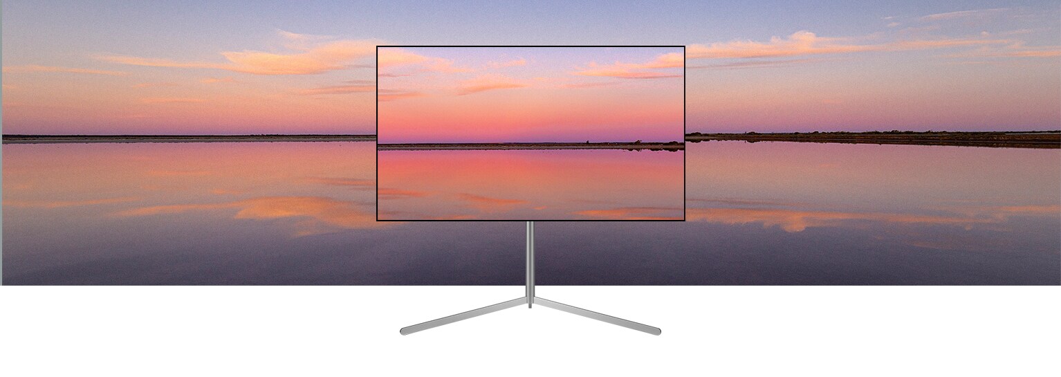 Un televisor LG OLED en un soporte Gallery muestra una puesta de sol azul y rosa que se funde con el fondo