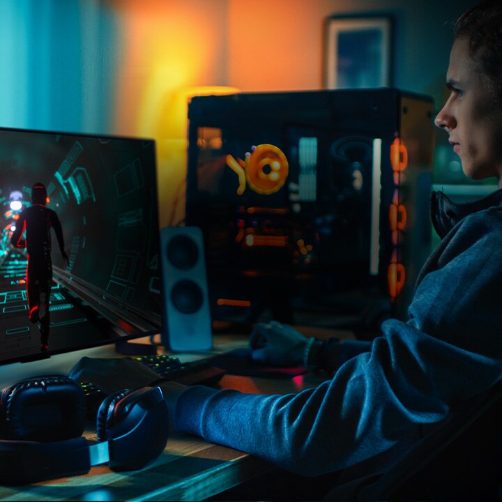 Una persona juega a un juego de ciencia ficción en su escritorio personal en un pequeño televisor LG OLED