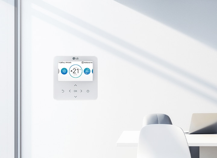 The image shows a clean office space with an LG control panel mounted on a white wall. The control panel displays a temperature setting of '21°C.	