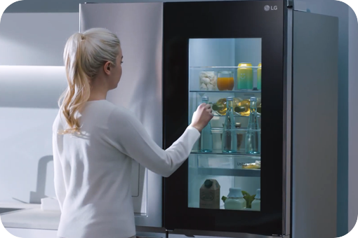 Eine Frau klopft an den Instaview Kühlschrank.