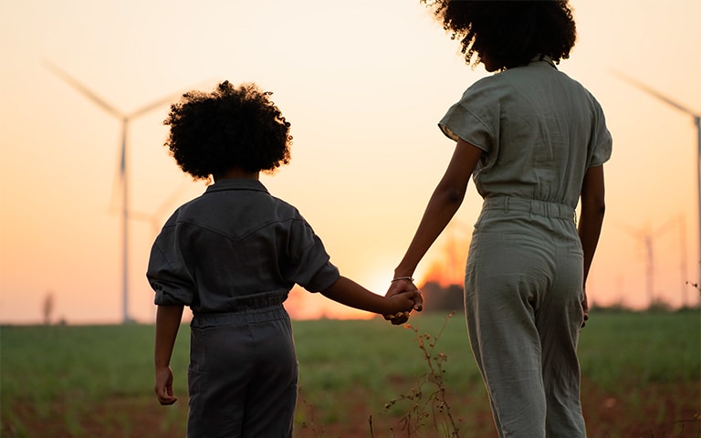 Young consumers standing in a field with wind turbines