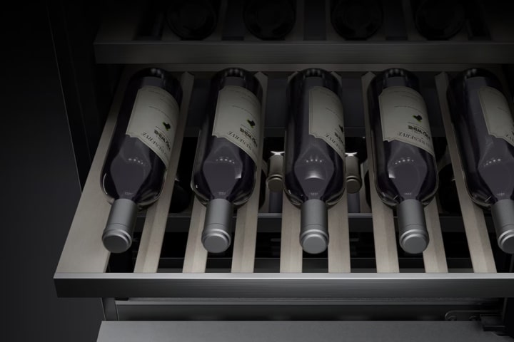 A close-up image of the inside of the wine cellar. Several bottles of wine are stored on the shelves, and the bottom shelf has been pulled out so that the wines can be easily viewed and accessed.