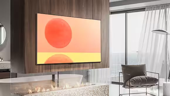 LG OLED G2 is hung on the wall in a brown and white room with red accessories