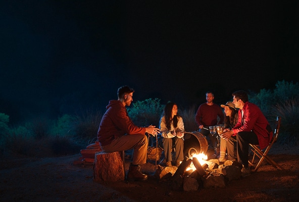 Gente sonriendo y disfrutando de un campamento, adoptando el poder del optimismo.