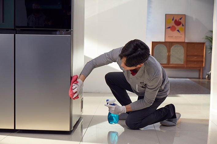 ชายทำความสะอาดตู้เย็น LG ด้วยผ้าสีแดงและน้ำยาทำความสะอาดในบ้าน, สมัครสมาชิก LG, โปรโมชั่น LG ล่าสุด, ข่าวสารผลิตภัณฑ์ LG.