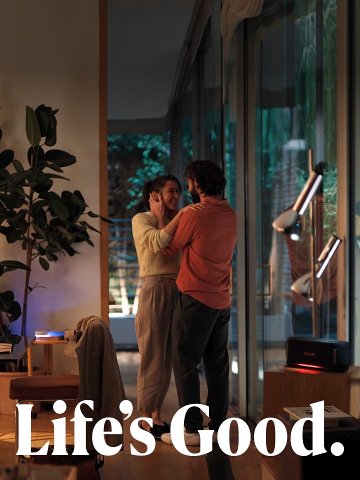 A woman and a man are looking at each other and smiling. At the bottom of the image, “Life’s Good.” is written in white.