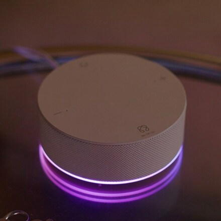 The white ThinQ ON product on the table emits a purple light.