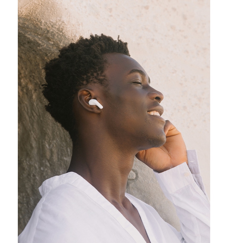 Un uomo indossa gli auricolari T90 e ascolta della musica con gli occhi chiusi.